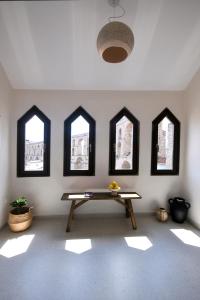 a room with a table in a room with windows at Plinthos Residence in Kavala