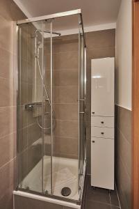 y baño con ducha y puerta de cristal. en Apartamenty Świnoujście -Żeromskiego 5 en Świnoujście