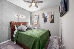 a bedroom with a green bed with a ceiling fan at Cozy Industrial Kildaire Farms Home- near Downtown in Cary