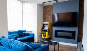a living room with blue couches and a tv at Withnell Stays - Apartment Five in Blackpool