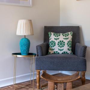 a blue chair with a pillow next to a lamp at Alba Cottage, Wilcot, Pewsey in Wilcot