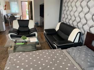 uma sala de estar com duas cadeiras e uma cama em Apartmány City em Ostrava
