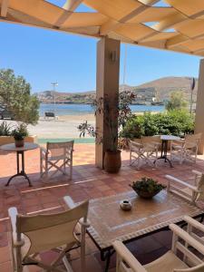 a patio with a table and chairs and a view of the water at Hotel Karthea in Korissia