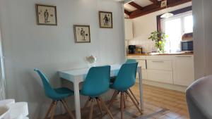 a kitchen with a table and four blue chairs at Les 4 mousquetaires in Méjannes-le-Clap
