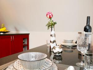 eine Küche mit einem Tisch mit einer Vase mit einer Rose in der Unterkunft Ferienwohnungen Schimsheimer Rhode in Olpe