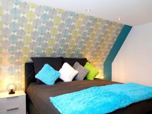 ein Schlafzimmer mit einem Bett mit einer blauen Decke in der Unterkunft Ferienwohnungen Schimsheimer Rhode in Olpe