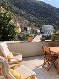 patio z krzesłami i stołem oraz góry w obiekcie Chez Jean Nonza w mieście Nonza