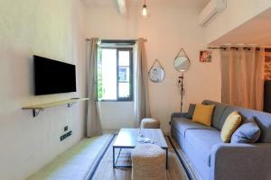 a living room with a couch and a tv at Lovely apartment in Saint-Paul-De-Vence in Saint Paul de Vence
