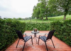 a patio with a table and two chairs on a brick patio at La Piconera Hotel & Spa in Ribadesella