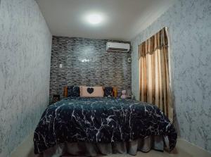 a bedroom with a bed and a brick wall at Beautiful 2-Bedroom Townhouse in Panglao Island in Dauis