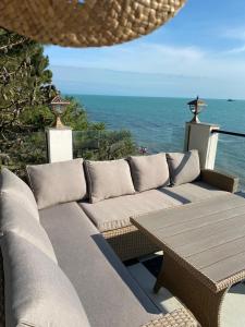 un patio con sofá, mesa y el océano en Claude Monet Seaside Hotel en Grigoleti