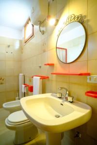a bathroom with a sink and a toilet and a mirror at Dimore Tarantini in Polignano a Mare +39 photos