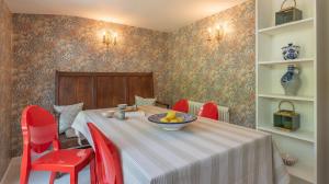 a table with red chairs and a bowl of fruit on it at Alba Cottage, Wilcot, Pewsey in Wilcot
