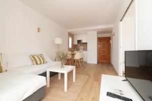 a living room with a white couch and a table at Bellamar Apartments in Port d'Alcudia