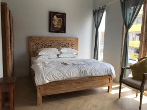 a bedroom with a bed and a chair and a window at Most Bali Malioboro Villa in Yogyakarta