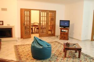 a living room with a couch and a tv at Canas Beach House - AL in Areia Branca