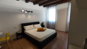- une chambre avec un lit doté d'un oreiller jaune dans l'établissement El Postesin, à Vérone