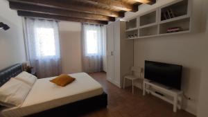 - une chambre avec un lit et une télévision à écran plat dans l'établissement El Postesin, à Vérone