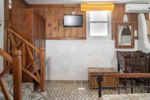 a living room with a tv on a wall at Alexandros by the Beach - Serifos in Livadakia