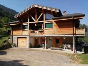 een groot houten huis met een veranda en een balkon bij Chalet Cathy et Michel in Seytroux