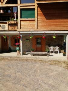 a house with two chairs and a porch with flowers at Chalet Cathy et Michel in Seytroux