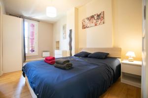a bedroom with a blue bed with towels on it at Cœur historique classé in Périgueux