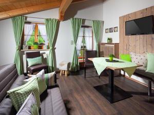 a living room with a couch and a table at Gästehaus und Ferienwohnungen Egglerlehen in Schönau am Königssee