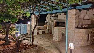 patio z kuchnią na świeżym powietrzu w nocy w obiekcie Nikolas Villa w mieście Ambelas