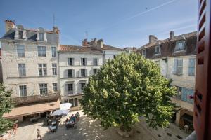 a group of buildings and a tree in a courtyard at Cœur historique classé in Périgueux