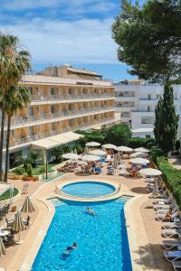 ein Hotel mit einem Pool, Stühlen und Sonnenschirmen in der Unterkunft HOTEL ALONDRA in Cala Ratjada