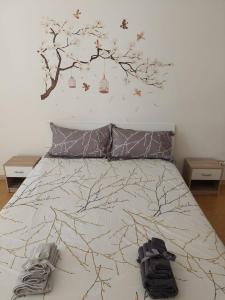 a bedroom with a bed with a tree mural on the wall at NICOLHOME in Rome