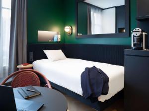 ディジョンにあるホテル イビス サントラルのベッド、テーブル、鏡が備わる客室です。