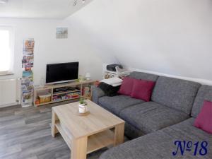 ein Wohnzimmer mit einem Sofa und einem TV in der Unterkunft Ferienwohnung Gerhards in Esens