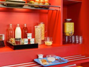 a red shelf with jars and other food items at hotelF1 Orange Centre Echangeur A7 A9 in Orange