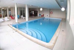 a large swimming pool in a building at Superbe appartement avec piscine sauna et petite vue mer in Plougonvelin