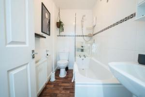 een witte badkamer met een toilet en een wastafel bij Kandaka-Modern Apartment in Belle Isle