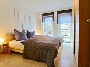 1 dormitorio con 1 cama y 2 ventanas en Komfort-Ferienwohnung am See en Bodman-Ludwigshafen