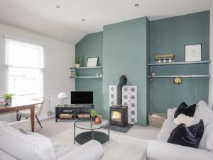 uma sala de estar com paredes azuis e uma lareira em The Old Barracks em Beaumaris