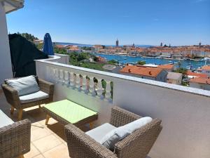 a balcony with chairs and a table and a view at Apartments Ivić in Rab