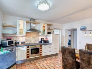 a kitchen with white cabinets and a stove at FeWo Tusculum in Zinnowitz