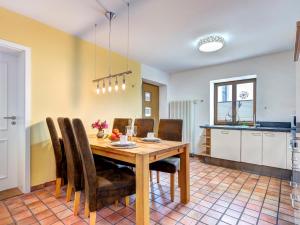 a kitchen and dining room with a wooden table and chairs at FeWo Tusculum in Zinnowitz