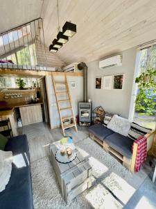 ein Wohnzimmer mit einem Etagenbett und einem Sofa in der Unterkunft Private cosy forest cabin in Inturkė