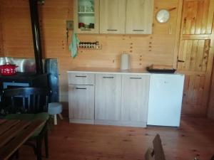 a kitchen with white cabinets and a white refrigerator at Vlajina brvnara in Arandjelovac
