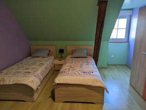 two beds in a room with green walls at Chez Patrick et Émilie in Bragelogne +16 photos
