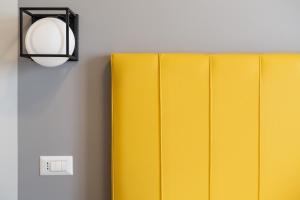 una pared con dos paneles amarillos y un interruptor de luz en Luciano Licia Guest House, en Roma 101 fotos más