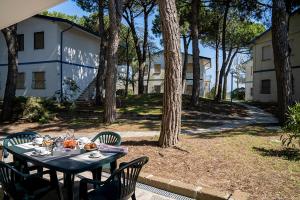 a table with food on it in a yard with trees at Nel verde a due passi dal mare in Lido di Spina