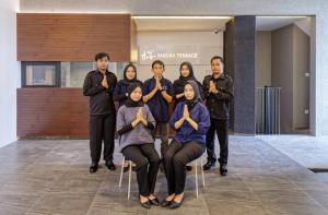 a group of people posing for a picture in a lobby at Sakura Terrace Benhil in Jakarta