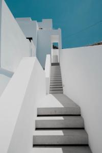 CUBIC Mykonos Seafront Design Suites في أورنوس: درج يؤدي الى مبنى بسماء زرقاء