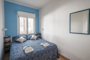 um quarto azul com uma cama com duas toalhas em Nel verde a due passi dal mare em Lido di Spina