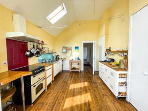 a large kitchen with white appliances and wooden floors at Quirky, Cosy 3BR Cottage With Patio in Canty Bay, Sleeps 10 in North Berwick